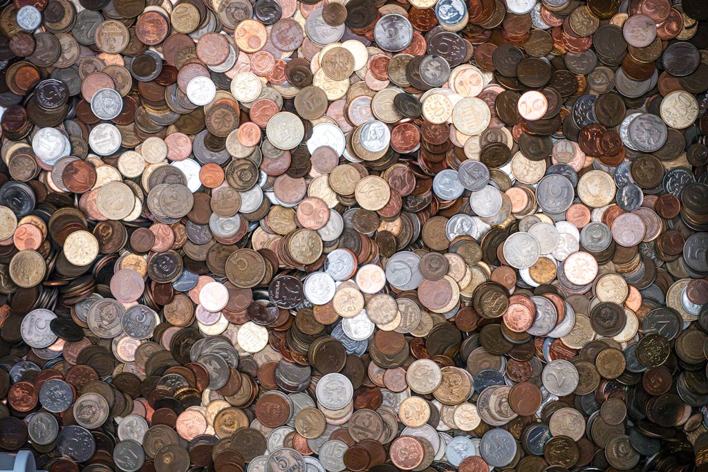 A diverse pile of various currencies' coins, offering a rich texture and metallic shine.