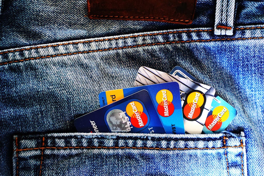 Close-up of a denim pocket with multiple credit cards, illustrating finance and fashion.