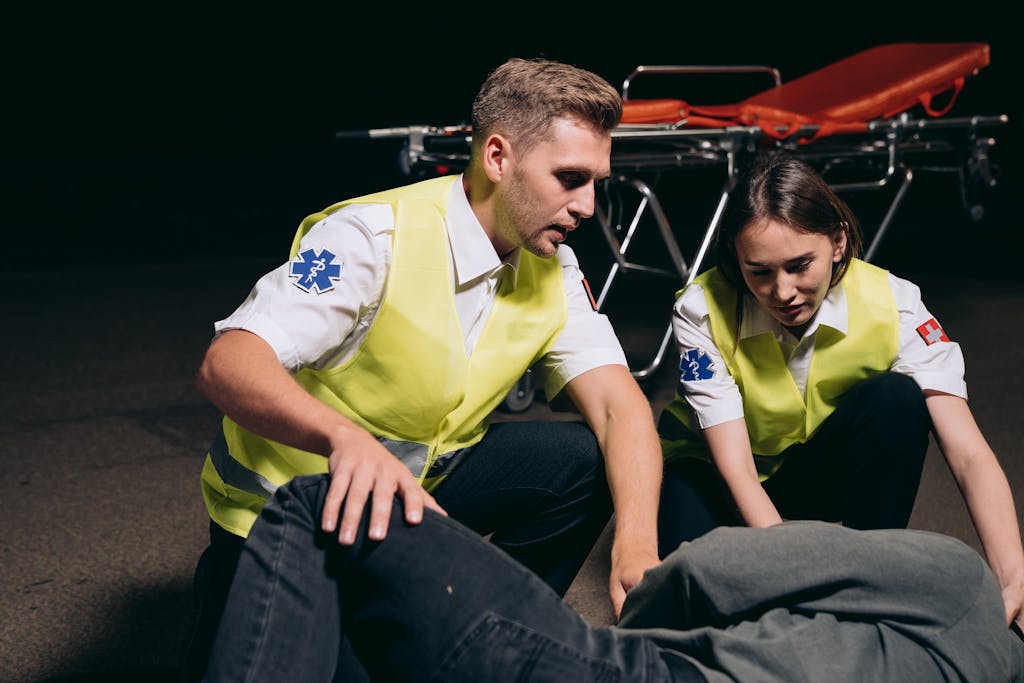 Paramedics provide emergency assistance to an injured person outdoors at night.